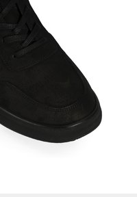 Baskets en daim noir avec une texture lisse, fermeture à lacets, bout rond, accents cousus et semelle en caoutchouc durable.