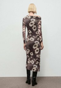 Rochie cu mâneci lungi, ajustată, cu un imprimeu floral în nuanțe de brun și crem. Fabricată dintr-un material moale, ușor, cu o croială medie.