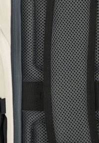 Matériau en maille noire avec un motif en grille, bordé de tissu gris. Inclut des sangles noires pour un maintien sécurisé. Surface texturée pour une meilleure adhérence.