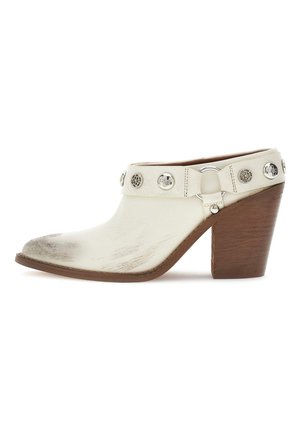 Mule en cuir blanc avec talon en bois épais, ornements en métal argenté et bout et côtés légèrement usés.