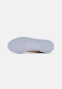 Shoe outsole in light blue rubber with a textured grip pattern and circular logo, featuring Reebok branding.