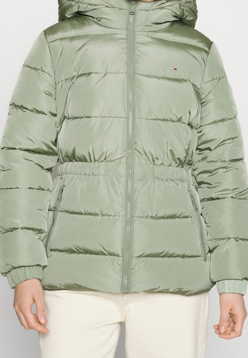 Olivově zelená péřová bunda, lesklý nylonový materiál, prošívaný design, přední zip, nastavitelná kapuce, elastické manžety, boční kapsy.