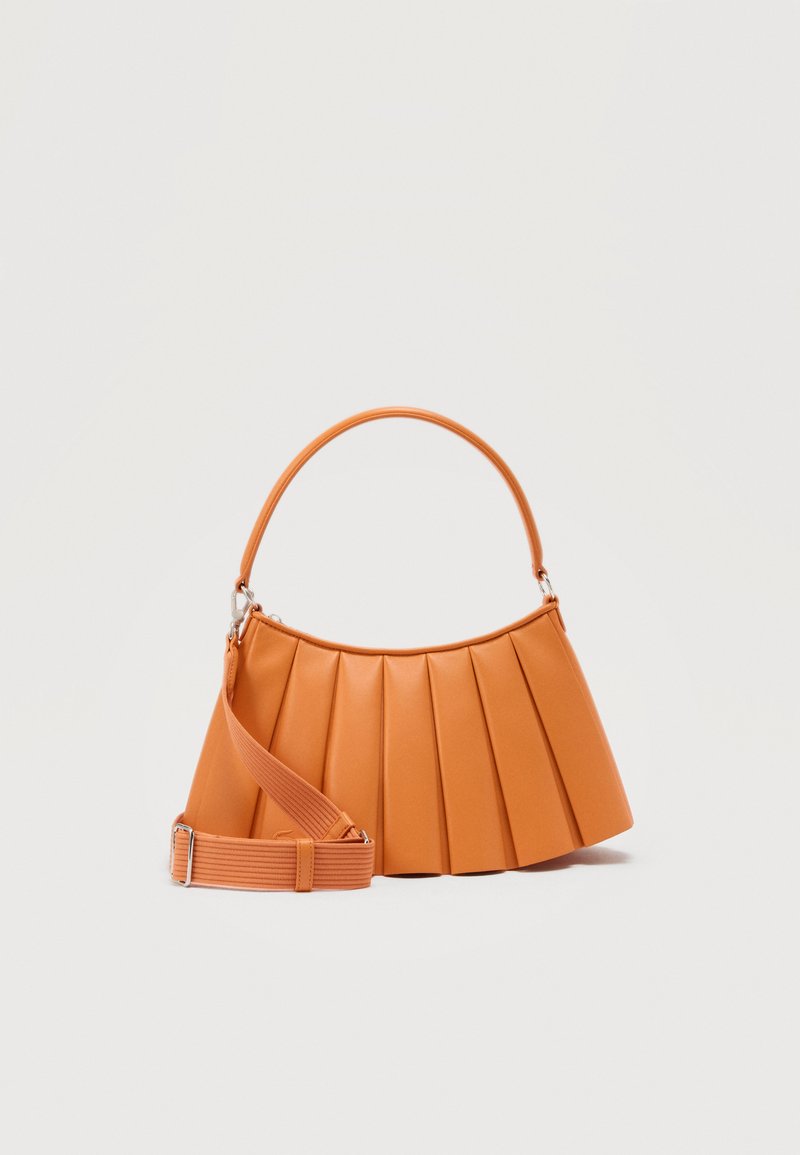 Tan pleated handbag with a curved top handle and an adjustable, detachable shoulder strap on a plain background.