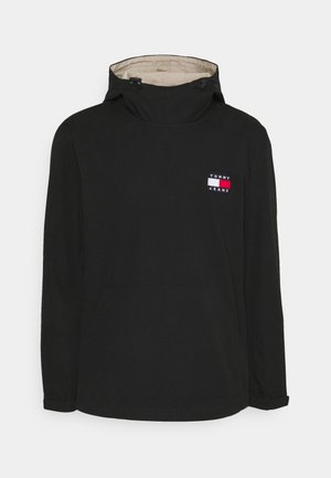 Schwarzer Kapuzenpullover mit beiger Innenfütterung, Front-Kängurutasche und kleinem Tommy Jeans Logo-Patch auf der Brust.