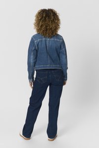 Chaqueta de denim con un diseño corto, lavado azul claro, costuras en contraste y cierre de botones en la parte delantera. Combinada con unos pantalones vaqueros acampanados de color azul oscuro.