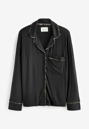 Maglietta da pigiama nera a maniche lunghe in materiale a coste con colletto, chiusura a bottoni, taschino sul petto e piping crema a contrasto lungo i bordi.