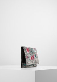Bolso de mano con cuentas que presenta material en tono plateado con bordado floral en rosa y verde, solapa plegable y un interior textil negro.