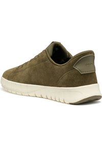  zapatilla de ante verde oliva con un diseño de corte bajo, parte delantera con cordones y una suela de goma cremosa y acolchada que presenta un patrón texturizado.