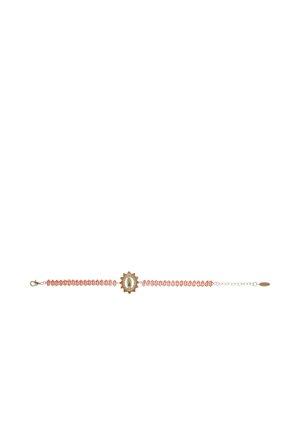 Bracelet avec des perles roses et un charm central en forme de soleil en or et argent, avec un petit dessin ovale au centre.
