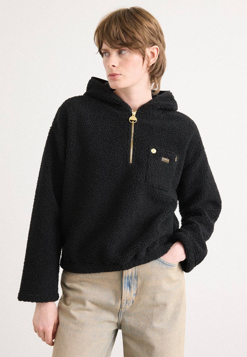Sweatshirt de fleece preto com fecho à frente, bolso tipo canguru e detalhes em ouro. Apresenta uma superfície texturizada e peluda, além de um corte descontraído.