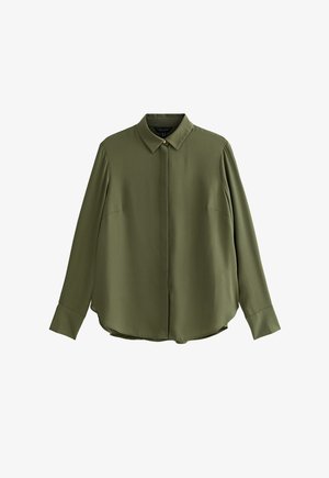 Długa bluzka w kolorze oliwkowej zieleni z ukrytymi guzikami z przodu, klasycznym kołnierzem i mankietami na guziki, rozłożona na płasko na białym tle.