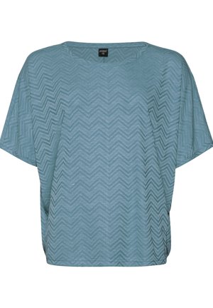 Haut bleu clair à manches courtes avec un motif en zigzag, coupe ample, col rond et texture douce. Étiquette visible au col.