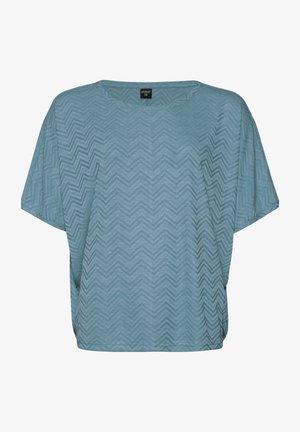 Svetlo modrý krátky rukáv top s cik-cakovým vzorom, voľný strih, okrúhly výstrih a jemná textúra. Na golieri je vidieť štítok.