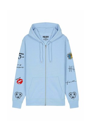 Helevale sinine tõmblukuga kapuutsiga jakk, mis on valmistatud puuvilla segust. Omab trükitud graafikat varrukatel, sealhulgas huuli, silmi ja fraase. Reguleeritav nööriga kapuuts.