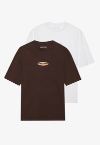 Deux T-shirts à manches courtes, l'un marron avec un logo orange et l'autre blanc, fabriqués en coton doux. Col rond, coupe décontractée, design basique.