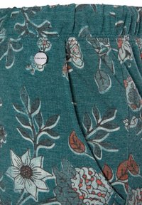 Turquoise fabric shorts met een bloemmotief, bestaande uit bladeren en bloemen in tinten van rood en wit. Elastische tailleband met een metalen logodetail.
