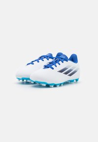 White soccer cleats with blue laces, blue inner lining, blue studs, and black striped design on a plain white background.