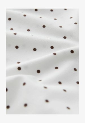 Valge kangas, millel on sile tekstuur ja laiali laotud väikesed pruunid täpiksed. Kangas paistab kergena ja langeb pehmelt.