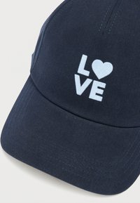 Granatowa czapka z bawełny z zaokrąglonym daszkiem. Z przodu haftowany napis „LOVE” w białym kolorze oraz symbol serca.