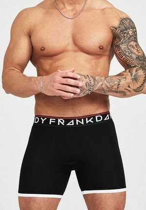 Svarta boxershorts med en vit midjeband som har "FRA"-logotypen i fet stil, stickad textur och en åtsittande design.