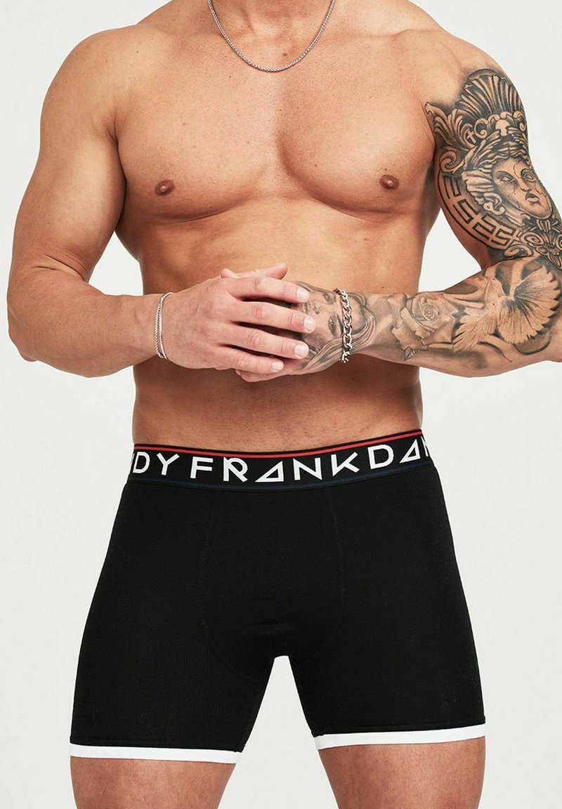 Svarta boxershorts med en vit midjeband som har "FRA"-logotypen i fet stil, stickad textur och en åtsittande design.