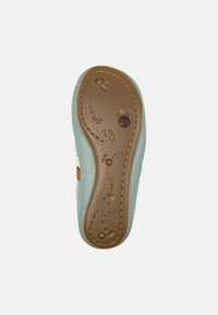 Suela de zapato infantil con parte superior de color azul claro, suela de goma color marrón claro, patrones de textura circulares y un acento marrón cerca del talón.