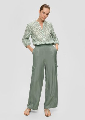 Light green blouse with a geometric pattern and long sleeves, paired with light green wide-leg cargo pants featuring side pockets.