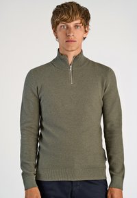 Olivgrüner Pulli mit Reißverschluss aus strukturiertem Strickstoff. Mit langen Ärmeln und Rippenbündchen sowie -saum. Eignet sich für die Freizeit.