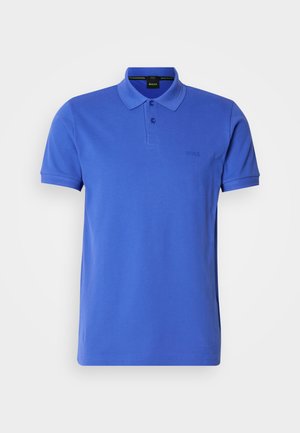 Polo azul de algodón, con cuello clásico, tapeta de dos botones y un sutil logo en el pecho. Mangas cortas y dobladillo recto.