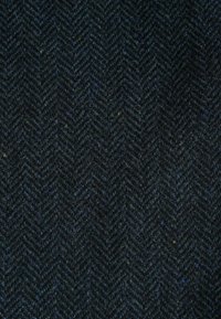 Tissu en laine bleu foncé avec un motif en chevrons et des variations subtiles dans la texture et la couleur du fil.