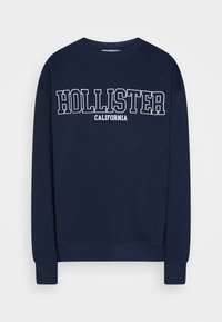 Granatowa bluza z okrągłym dekoltem, z białym napisem "HOLLISTER CALIFORNIA" w pogrubionej czcionce. Wykonana z miękkiej mieszanki bawełny.
