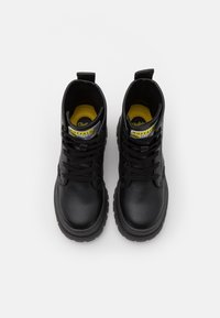 Bottes noires jusqu'à la cheville en cuir texturé, avec accents de logo jaunes et bleus, fermeture à lacets, et semelle épaisse.