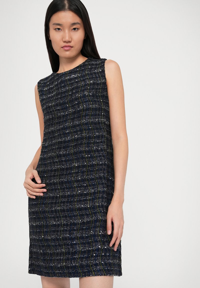 Marineblaue Shiftkleid mit einem strukturierten Gewebe-Muster, das goldene und silberne Fadenakzente aufweist. Kurze Ärmel und knielanger Schnitt.