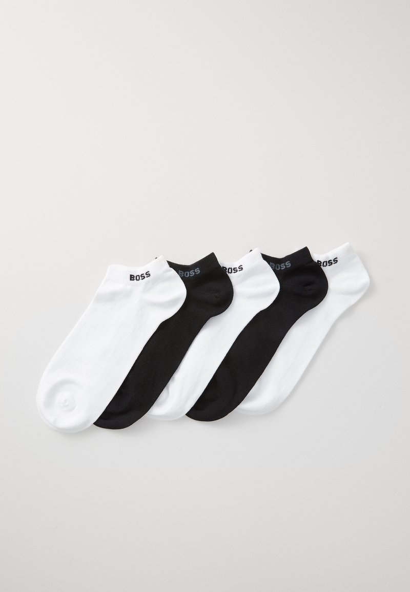 Calzini alla caviglia bianco e nero, in misto cotone, con bordo a costine e logo "BOSS" sulla parte superiore. Quattro paia disposti in modo alternato.