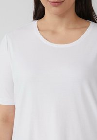 Witte korte mouwen t-shirt met een ronde halslijn, gemaakt van gladde stof met een zachte textuur, zonder zichtbare patronen of accenten.