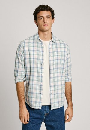 Licht geruit overhemd in blauw, groen en wit, gemaakt van zachte stof. Afgewerkt met knopen en opgerolde mouwen, gelaagd over een plain witte T-shirt.