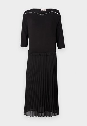 Must mustaga, millel on pealehed ja pleeritud seelik. Kaal on ümar kaelus, millel on hõbedased nurgad ja kolmveerandi pikkused varrukad.