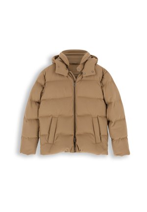 Homme portant une doudoune à capuche beige, un pantalon foncé, des baskets noires et un pull foncé sous la veste ouverte, debout devant un fond neutre.