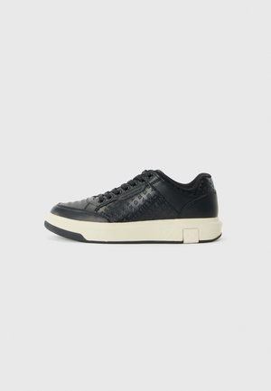 Sorte lær sneakers med teksturert design, kremfarget gummisåle, rund tå og snøring. Har logo-akkenter på sidene.