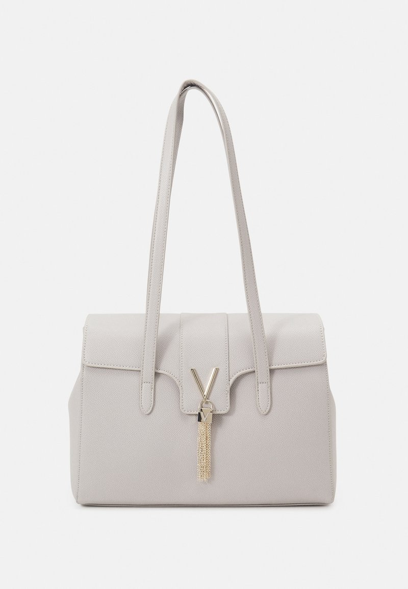 Grå texturerad handväska med två långa handtag, med en klaffstängning, en guldtonad V-formad lås och en dekorativ detalj i form av en tofs.