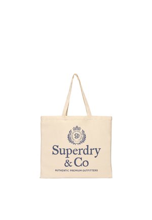 Sac fourre-tout beige avec des anses fines et "Superdry & Co Authentic Premium Outfitters" imprimé en bleu avec une crête décorative au-dessus du texte.