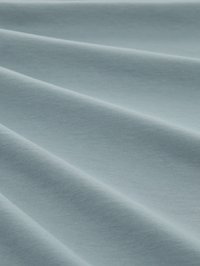 Gaiši zils audums ar gludu tekstūru, kas izceļas ar mīkstiem krokām. Materiāls ir vienmērīgi austi, demonstrējot vienmērīgu un smalku spīdumu.