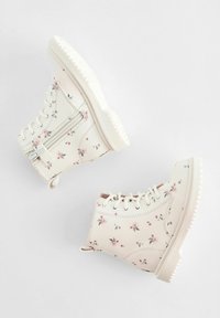 Bottines imprimées florales en crème clair, dotées d'une fermeture éclair, d'un bout rond et d'une semelle en caoutchouc blanc texturé.