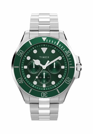 Timex karóra zöld számlappal és lünettával, ezüst jelzőkkel, három segédszámlappal és rozsdamentes acél szíjjal, az idő 10:10:09-et mutat.