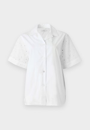 Hvid kortærmet skjorte med knaplukning foran. Hoveddelen er lavet af ensfarvet stof, mens ærmerne har et blomstret øjenlågdesign.