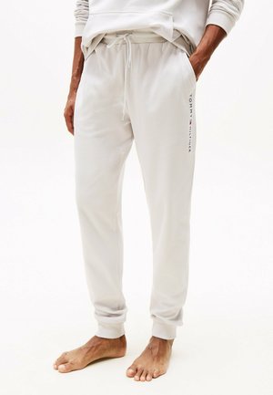 Hellgraue Jogginghose mit elastischem Bund und Kordelzug. Sie verfügt über seitliche Taschen und dezente "Tommy Hilfiger"-Markenkennzeichnung am Bein.