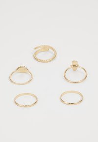 Set van vijf gouden ringen met verschillende ontwerpen: één gedraaid, één met textuur en drie eenvoudige banden zonder versieringen.