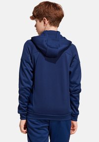 Marineblauwe hoodie met een trekkoordcapuchon, gestructureerde stof en ribbelmanchetten. Heeft een eenvoudig, gestroomlijnd achterontwerp zonder logo's.