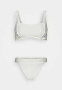 Conjunto de biquíni branco com tecido texturizado. O top apresenta um design estruturado com alças largas, enquanto a parte de baixo é um estilo simples de tanga.