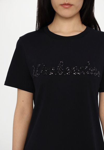 Sort bomulds T-shirt med korte ærmer, der har teksten "Weekender" i sorte paljetter på tværs af brystet. Glat tekstur; klassisk pasform.
